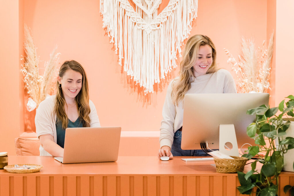 Two creative female entrepreneurs typing on computers