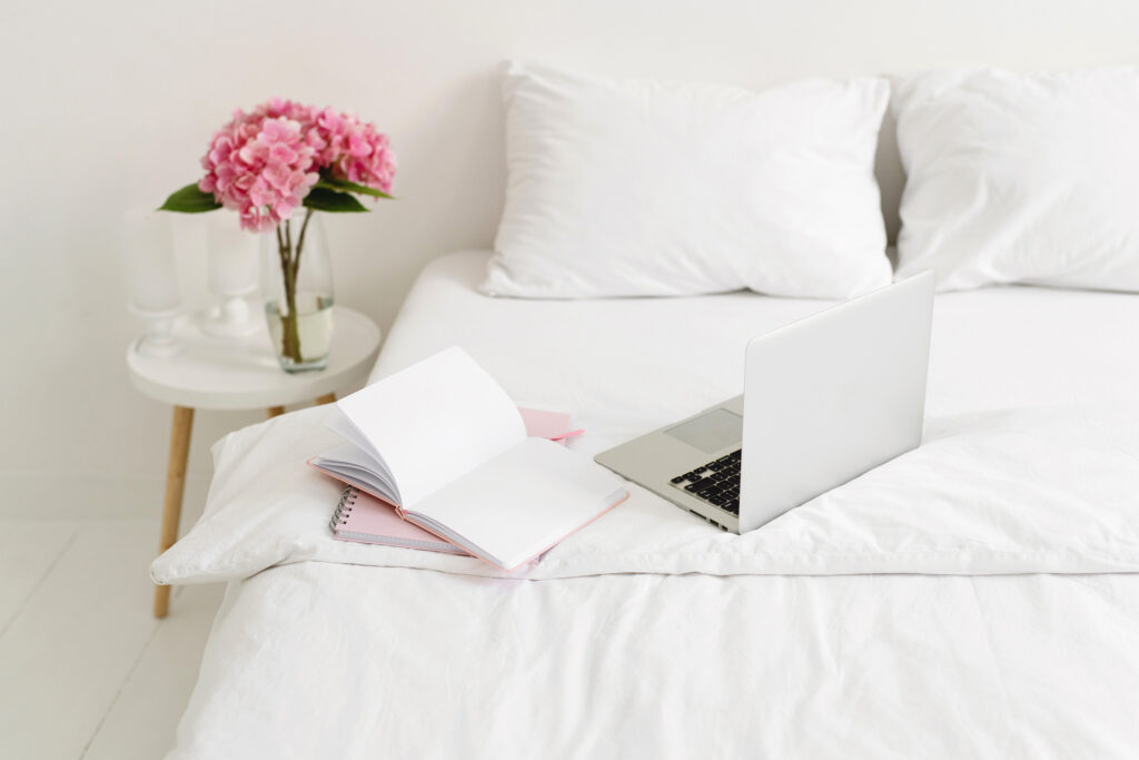 open laptop on white bed